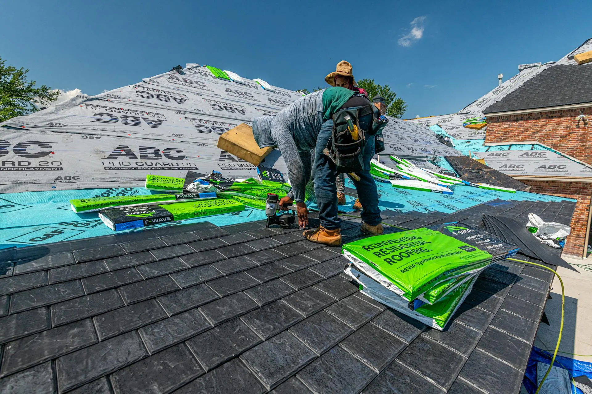 Roofing contractor working on a residential roof on a clear Kentucky afternoon