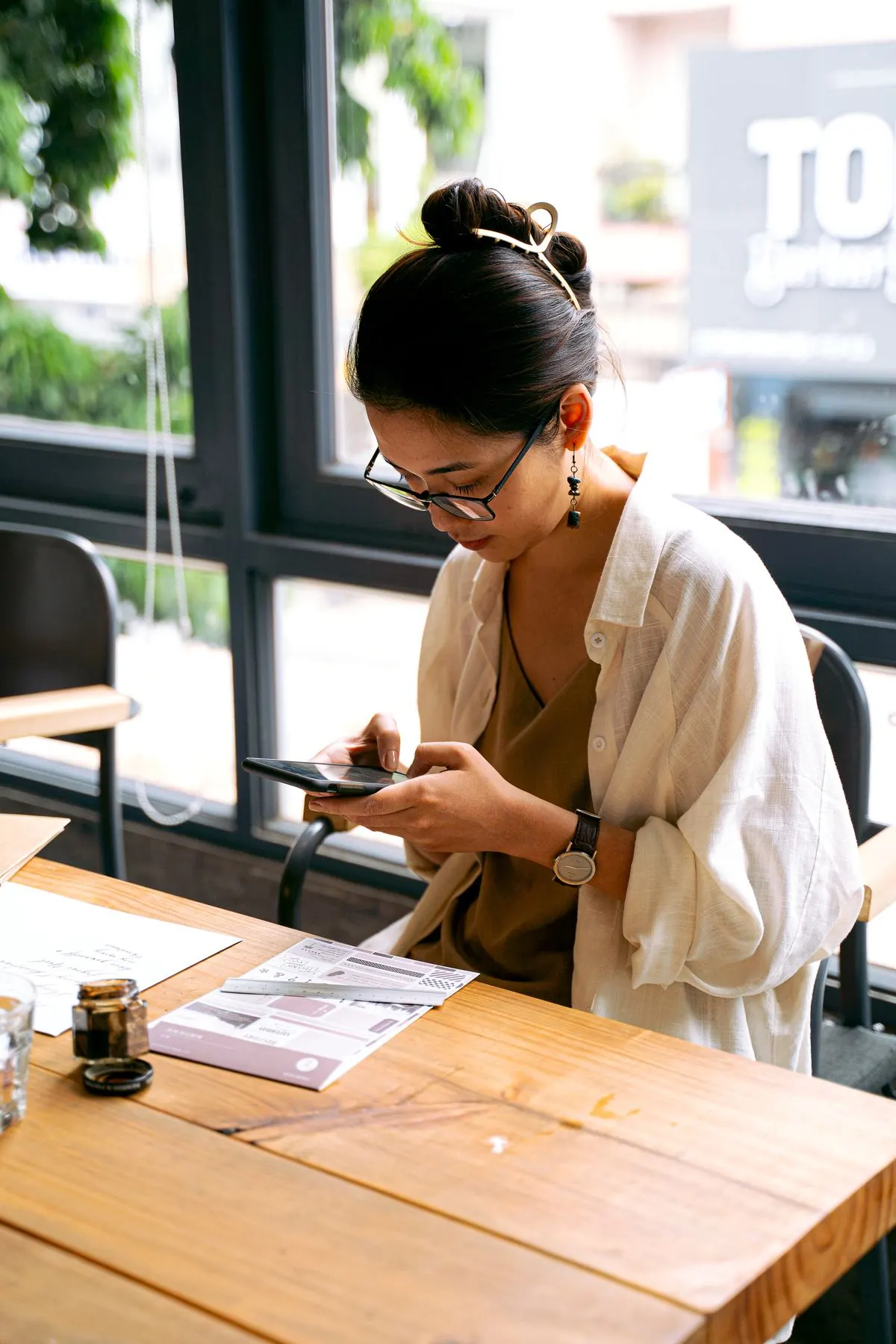 Customer looking up a restaurant on her phone at a cafe table