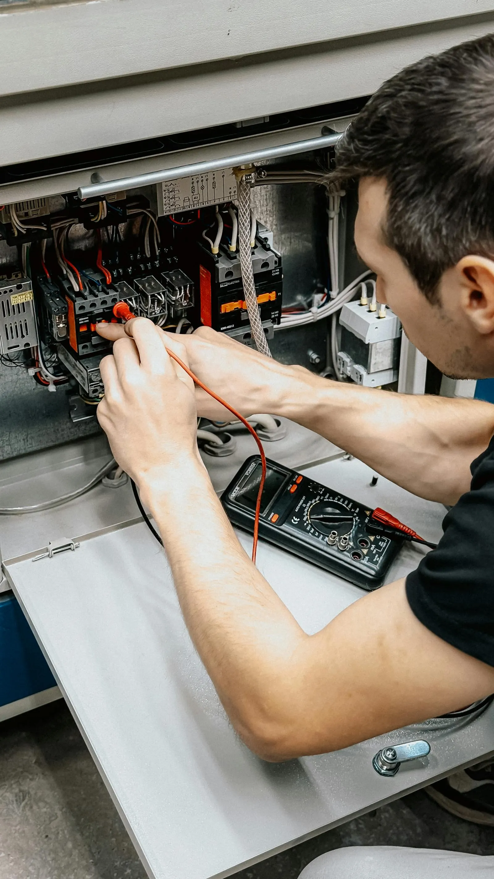 Electrician wiring a residential electrical panel during a service upgrade